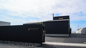 A black gate with "PLATINUM REST" written on it, leading to a building with a dark roof and a small window. - PLATINUM RESORT 1 Villa with Infinity Pool with Private Beach Water Bike Boat unloading available (bring your own) Vacation Rental (大津市)