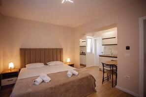 Une chambre d’hôtel avec un lit, des tables de chevet, un bureau et une chaise.