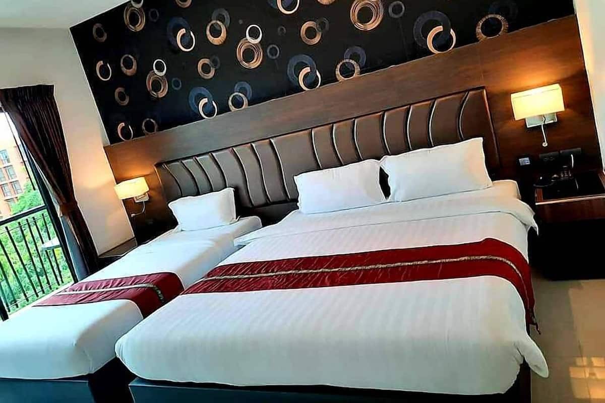 A hotel room with two beds, a modern headboard, and a decorative wall with circular patterns.