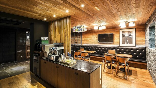 A cozy cafe with a wooden interior, a self-service bar, and a seating area with a TV. - Bellino Hotel (Osan)