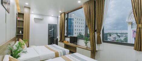 Panorama vierpersoonskamer, uitzicht op de stad | Een minibar, een strijkplank/strijkijzer, gratis wifi, beddengoed