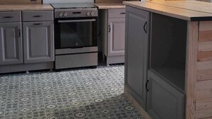 Uma cozinha com forno embutido, micro-ondas e bancada de madeira.
