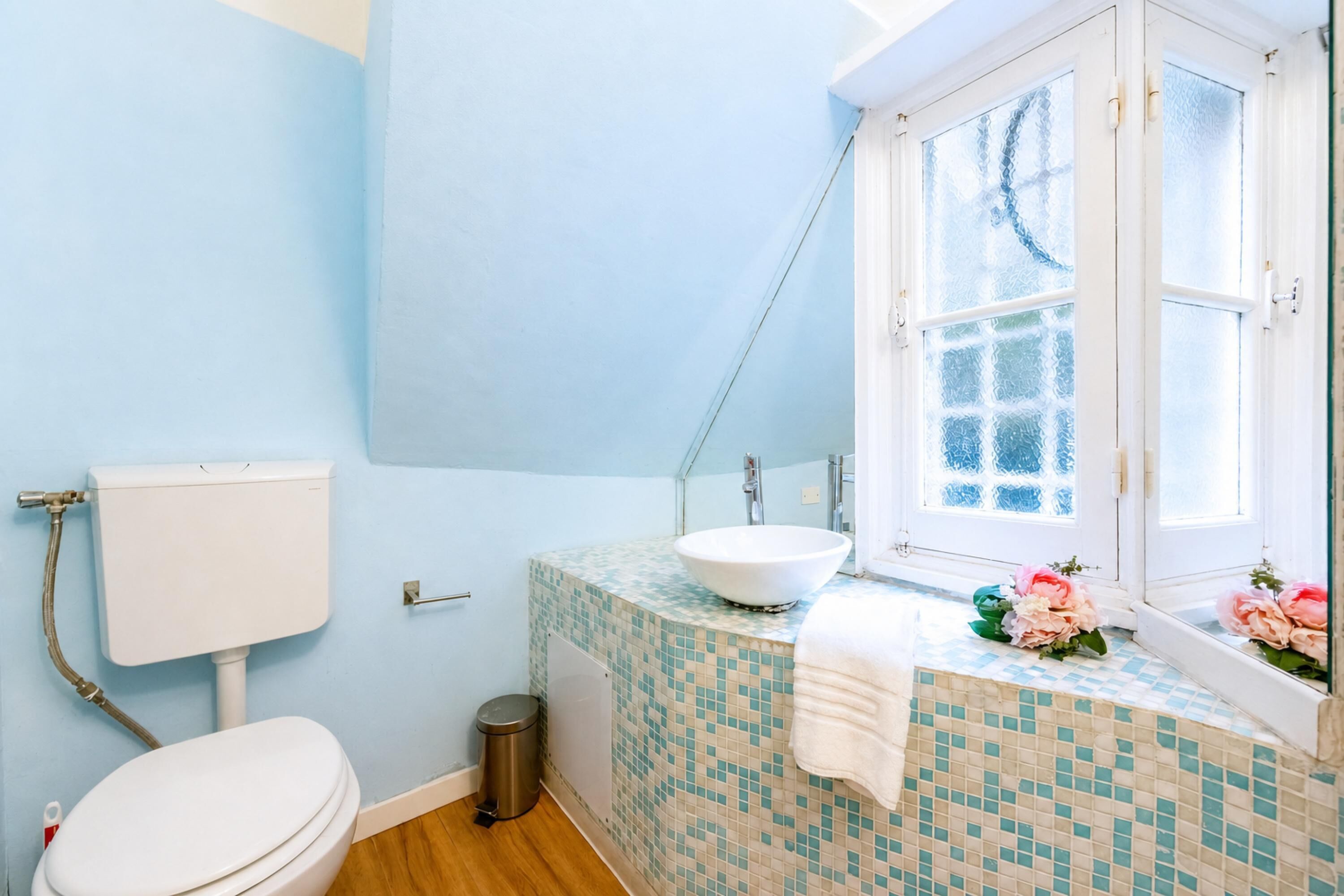 Une salle de bain avec des toilettes, un lavabo et une fenêtre.