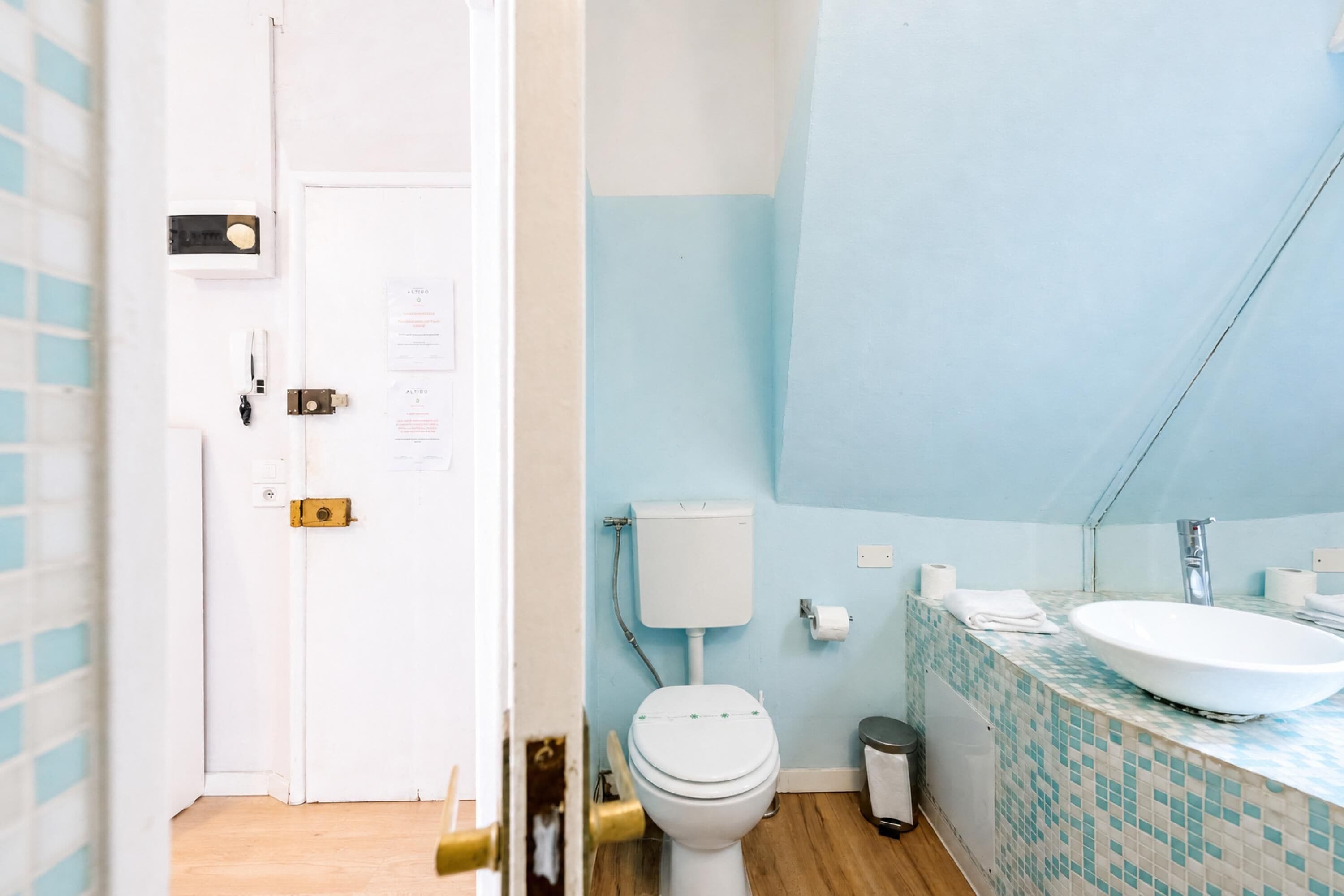 Ein Badezimmer mit Toilette, Waschbecken und gefliesten Wänden.