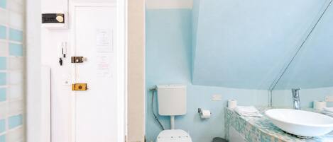 Ein Badezimmer mit Toilette, Waschbecken und gefliesten Wänden.
