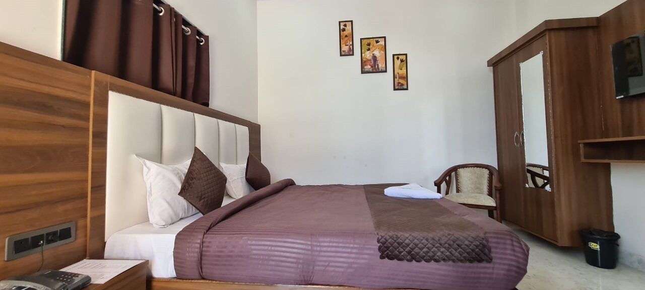 Een slaapkamer met een bed, een houten garderobe en een stoel.