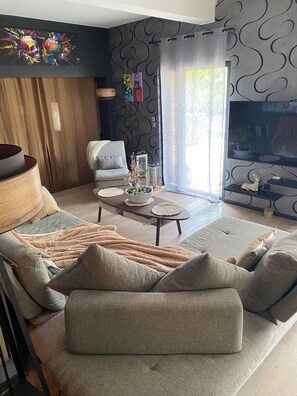Relax in this stylish living room with a plush sofa, coffee table, and mounted TV.