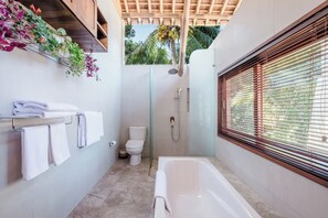 A modern bathroom with a glass-enclosed shower, a toilet, and a bathtub. - Villa Bambooz Sari (Ubud)