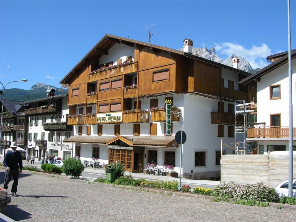 A hotel with a wooden facade, balconies, and a sign reading "HOTEL VIVA."