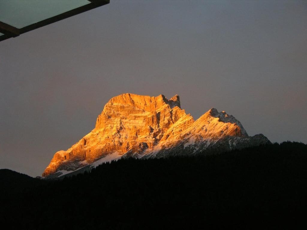 A mountain with a distinct peak and a flat-topped structure at the base.