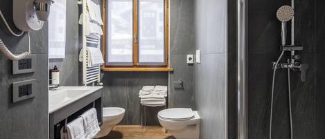 Un baño moderno con ducha, inodoro y lavamanos.