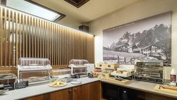 A breakfast bar with various food items and a coffee machine.