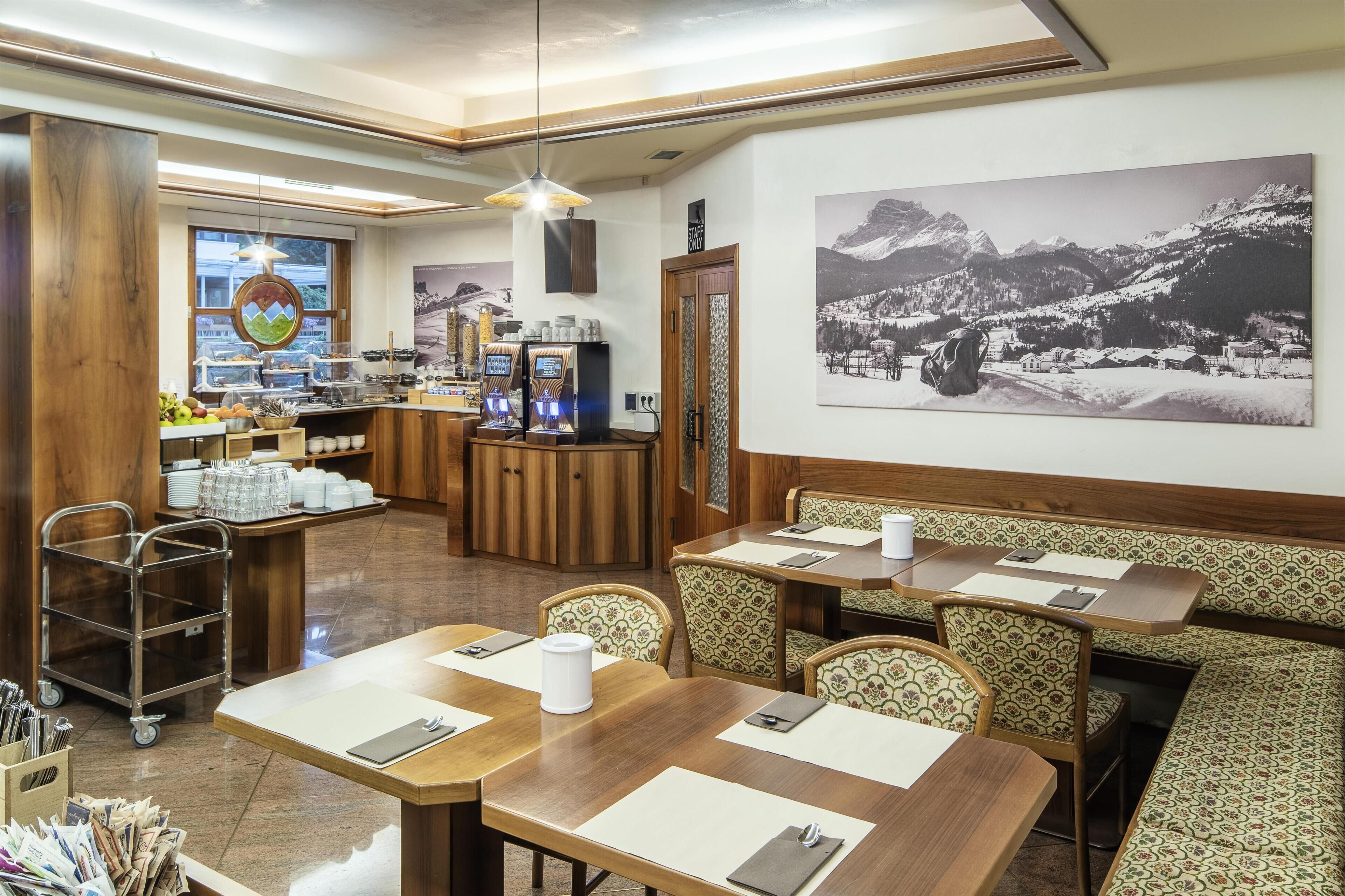 Un restaurante con mobiliario de madera, zona de bufé y vistas a la montaña.
