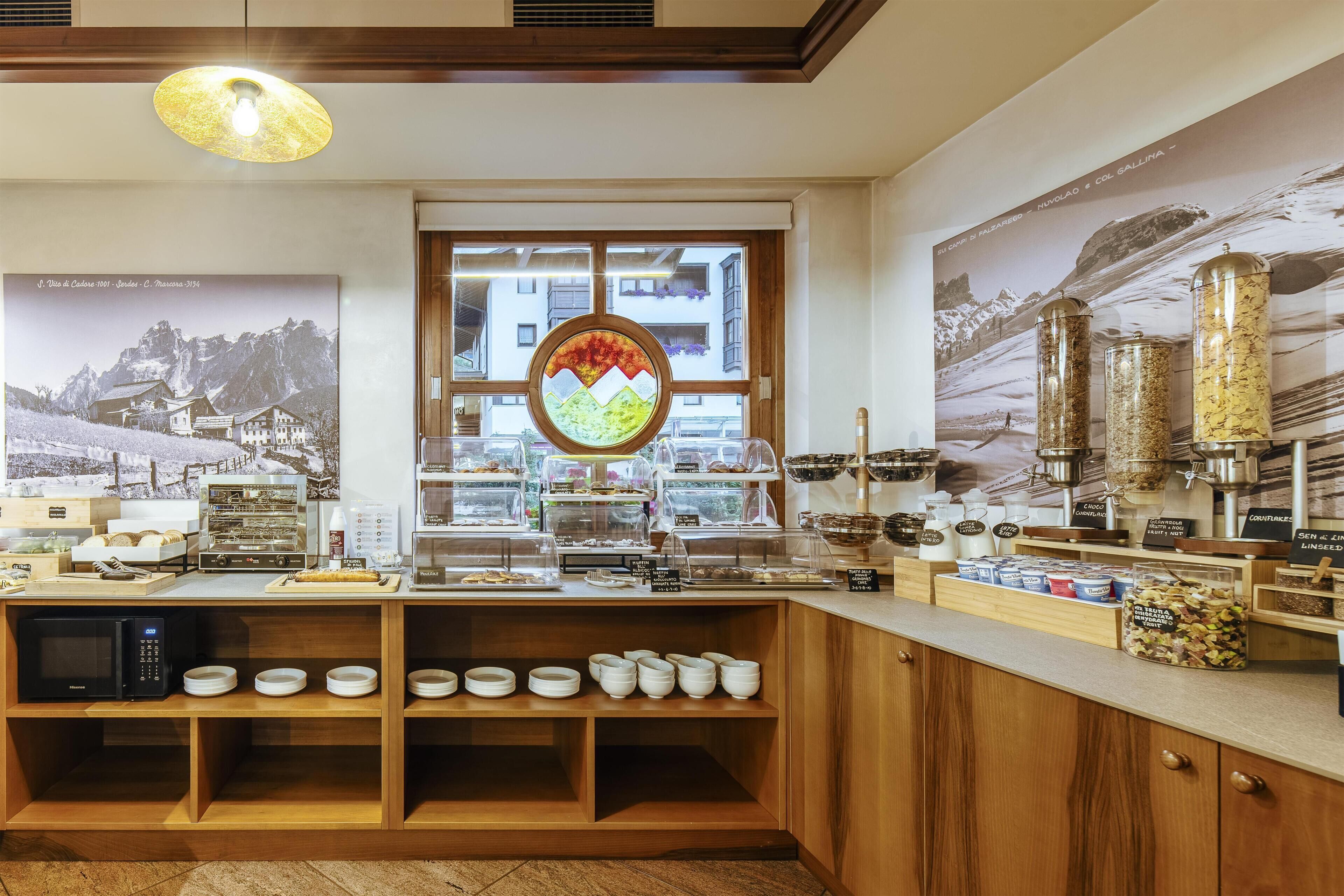 Un ricco buffet della colazione con diverse pietanze e un angolo dedicato al caffè.