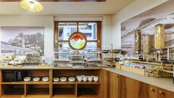 Un ricco buffet della colazione con diverse pietanze e un angolo dedicato al caffè.