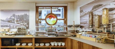Un buffet de petit-déjeuner proposant une variété d’aliments et un coin café.