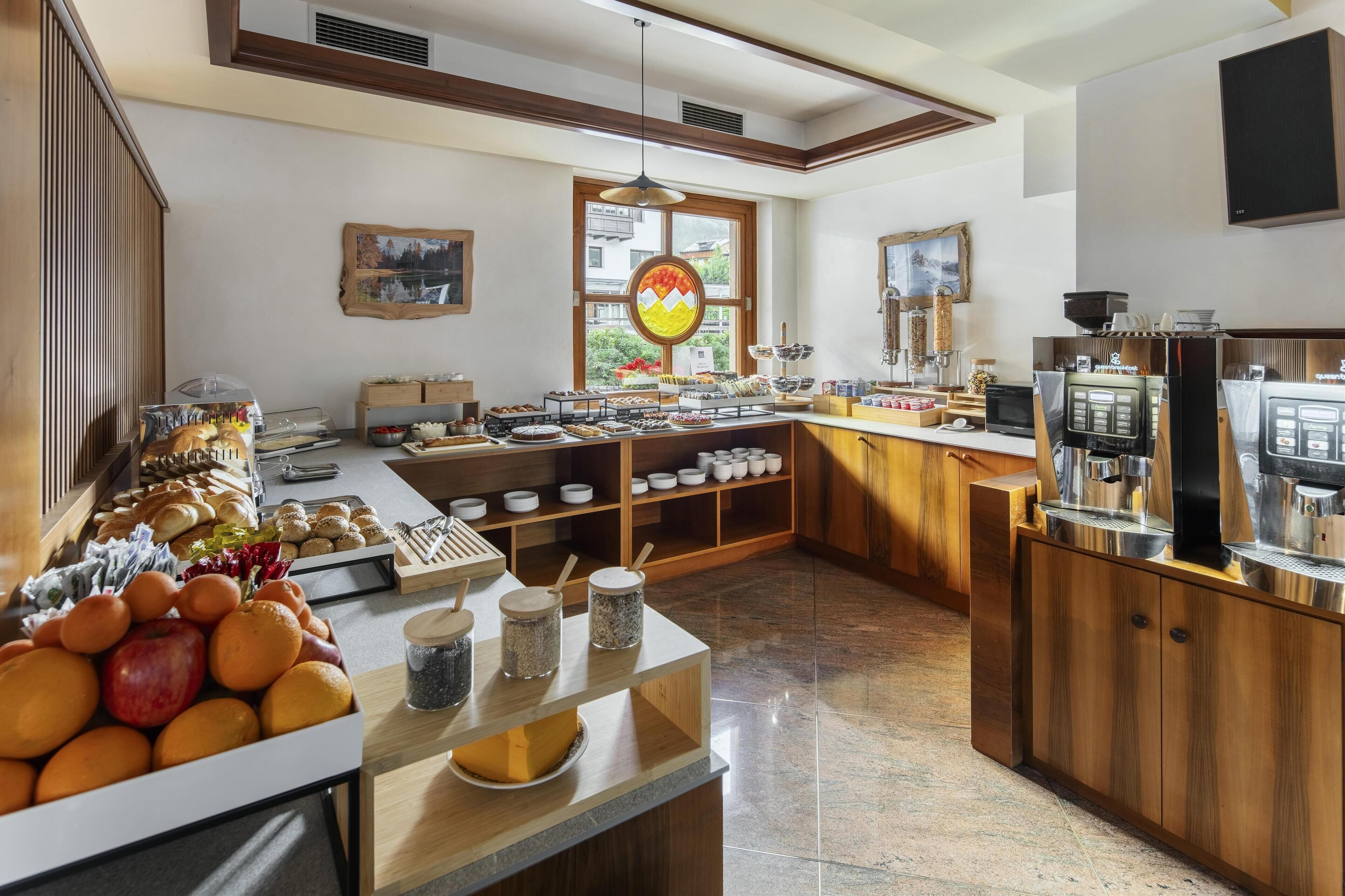 A modern kitchen with a buffet setup, including a variety of food items and a coffee station.