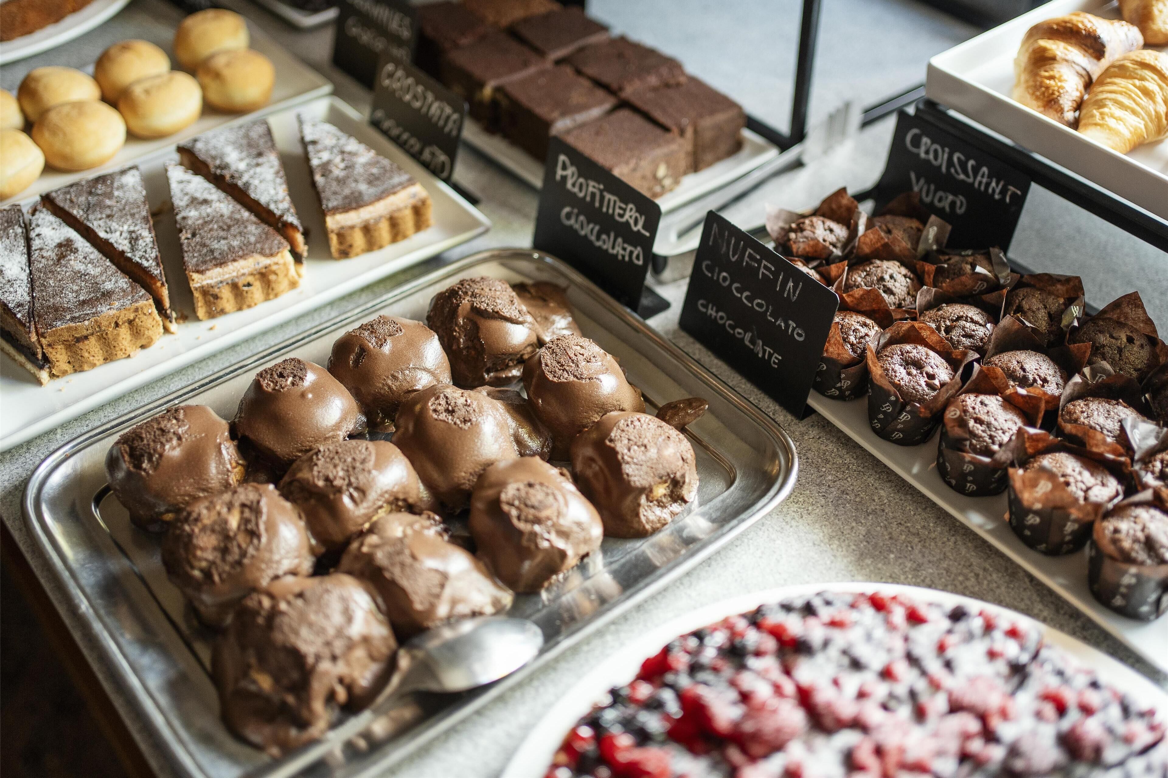A variety of desserts including chocolate-covered treats and pastries, with labels indicating types like "Profiterol Chocolat" and "Croissant Yvrod".