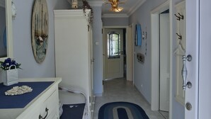 A hallway with a white wardrobe, a blue mat, a chandelier, and a door leading to another room. - Apartment for 2 pers. close to the beach approx. 700 m, incl. WLAN (Graal-Müritz)