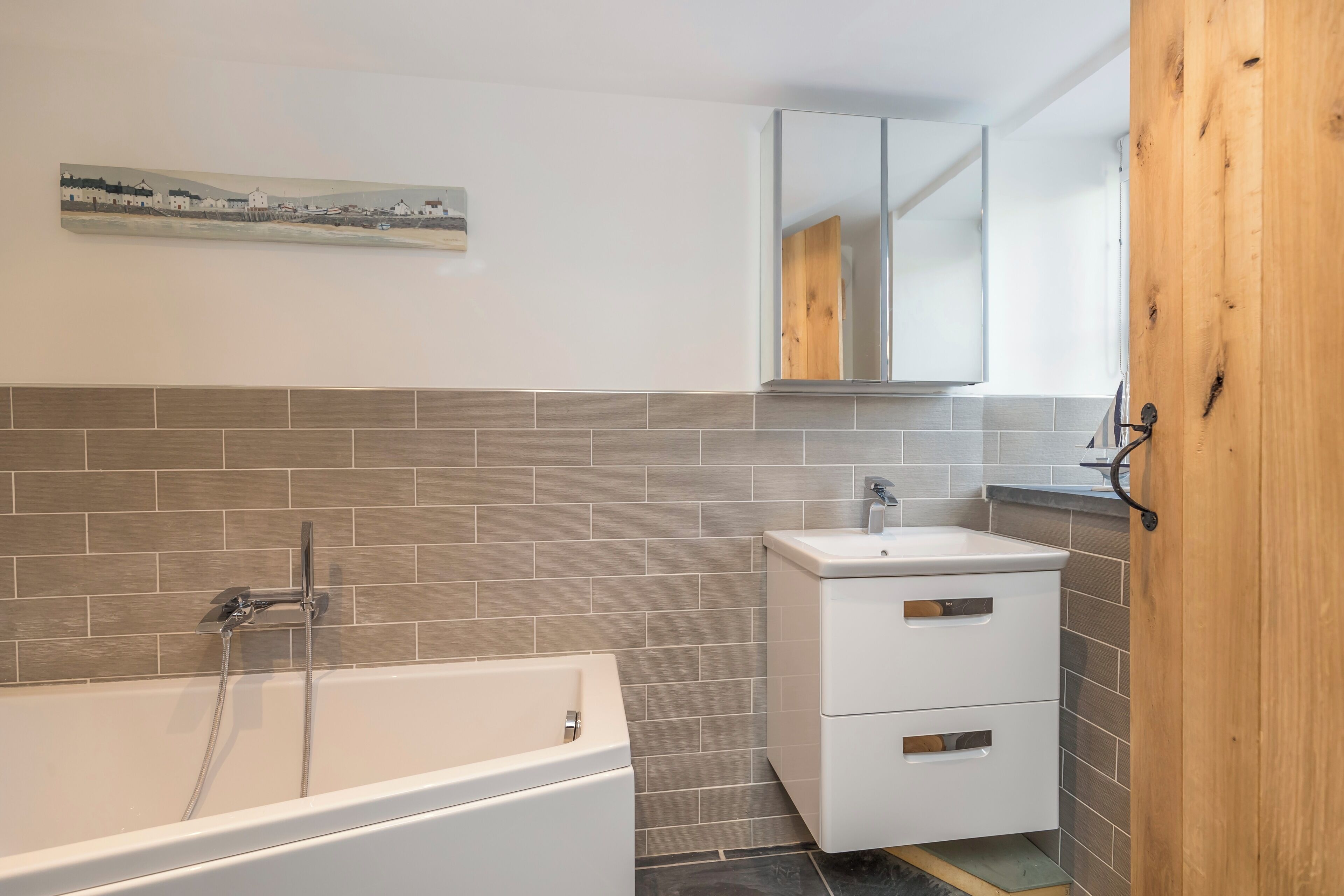 Un baño con bañera, lavabo y espejo.
