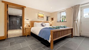 A bedroom with a bed, bedside tables, a window, and a door.