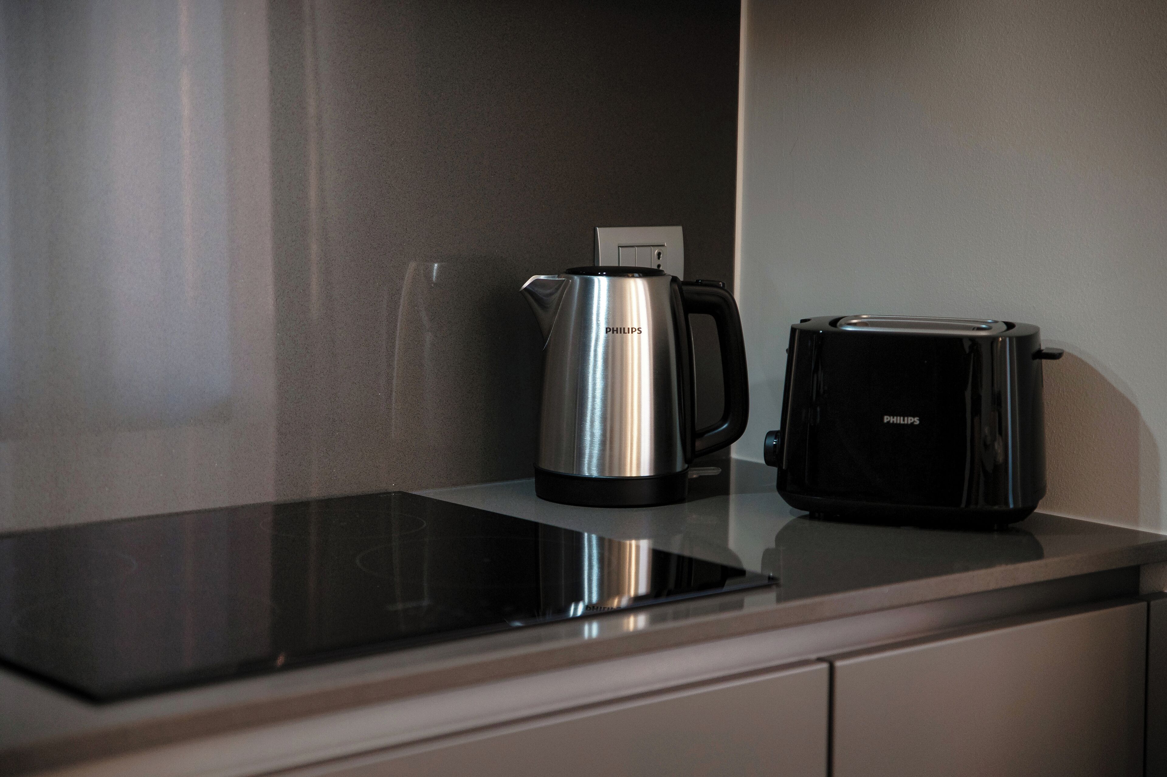 A kitchen counter with a stainless steel coffee maker and a black toaster.