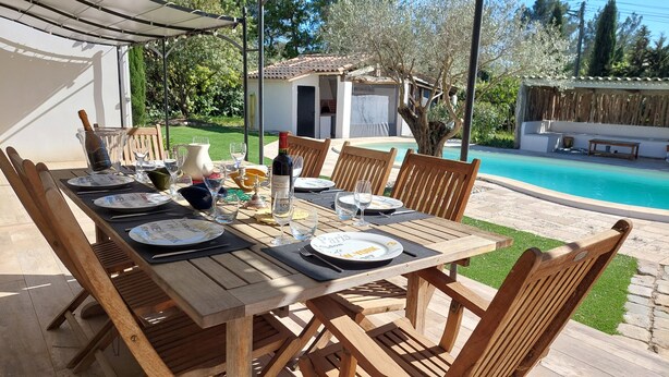 A wooden dining table set for six with plates labeled "Paris," "London," and "New York."