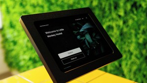 A digital kiosk with a welcome message for Little Monkey Hostel.