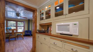 Cucina con mobili in legno, un forno a microonde e un piano cottura blu.