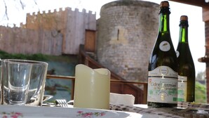 A table with a bottle of Cidre Fermier de Normandie wine, a candle, and glasses.