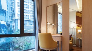 A modern hotel room with a large window, a desk, a chair, and a mirror. - Saigon Aroma Hotel (Hanoi)