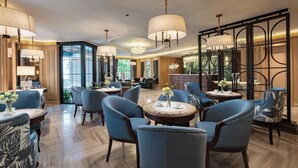 A spacious hotel lobby with multiple seating areas, large chandeliers, and a reception desk. - Saigon Aroma Hotel (Hanoi)