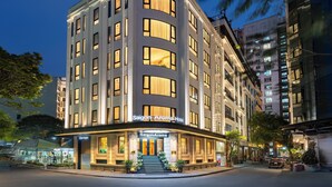 A multi-story hotel with a classic architectural style, featuring a prominent entrance with a staircase and potted plants. - Saigon Aroma Hotel (Hanoi)