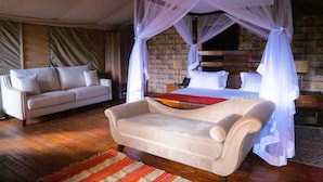A room with a bed under a canopy, a sofa, and a wooden floor. - Nokras Enkare Luxury Tented Camp Sagana (Sagana)