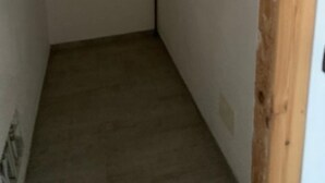 A narrow hallway with a wooden door frame and a visible electrical outlet on the wall.