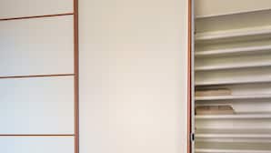 Une pièce dotée d’une porte coulissante donnant accès à un placard avec des étagères.