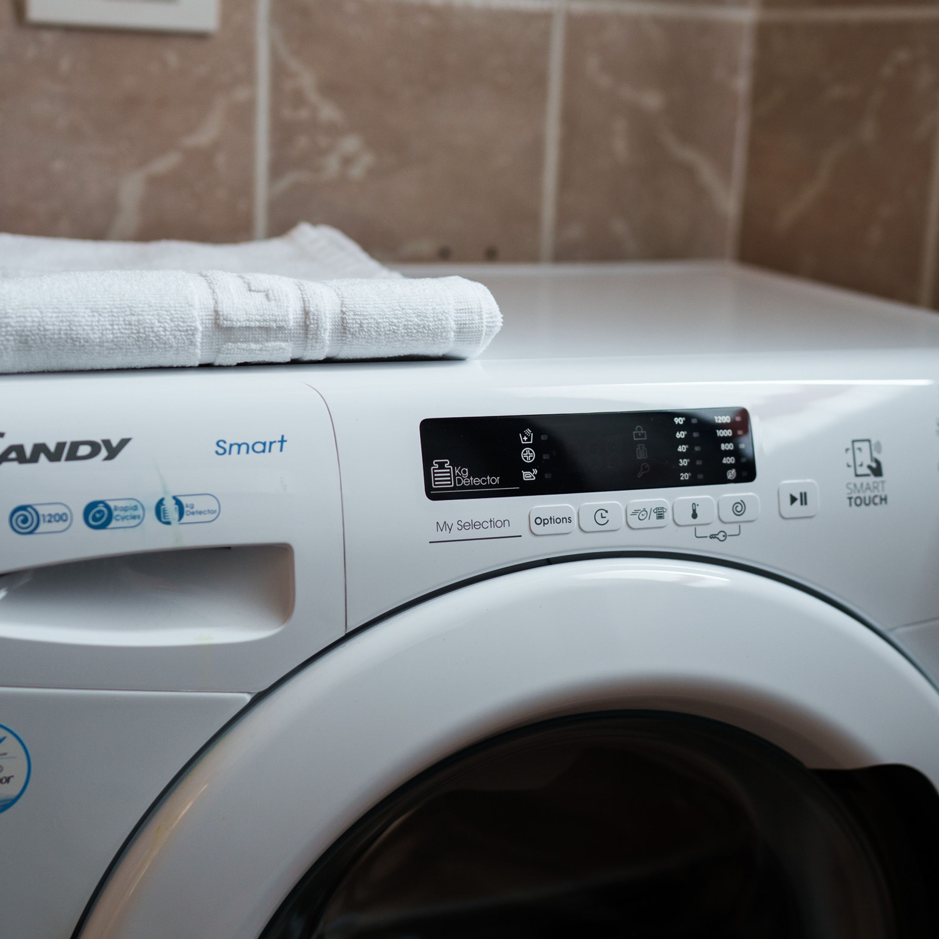 A front view of a white washing machine with a digital display and control panel.