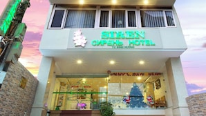 A hotel with multiple floors, a staircase leading to the entrance, and a Christmas tree decoration. - Siren Flower Hotel (Nha Trang)