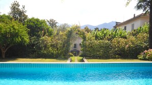 A swimming pool with a clear view of a building in the background. - Villa Dell Artista by Elite Villas (Cernobbio)