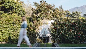 A pathway leading to a house with a covered porch, surrounded by lush greenery and flowering bushes. - Villa Dell Artista by Elite Villas (Cernobbio)
