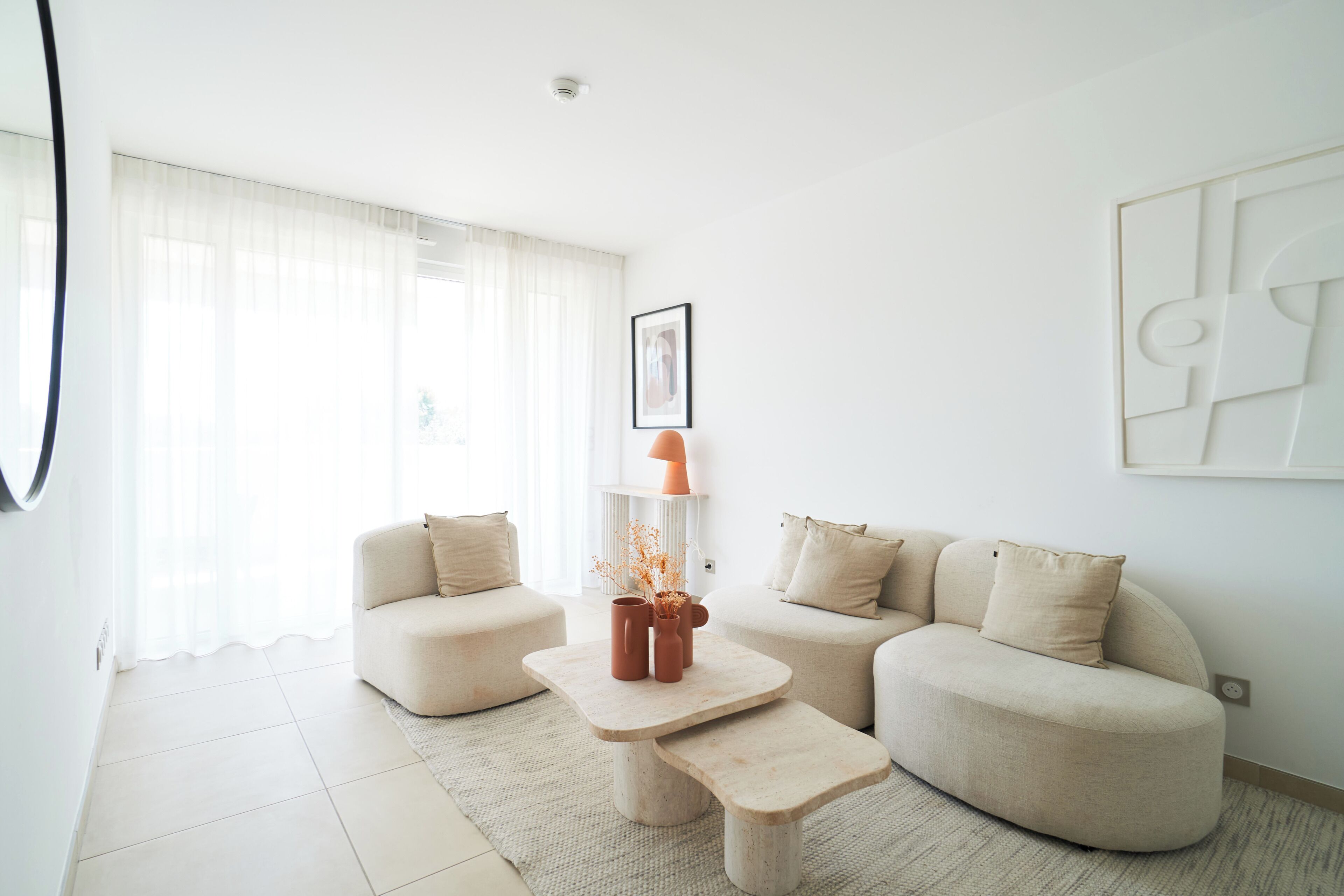 Un salon moderne comprenant un canapé, une table basse et une lampe.