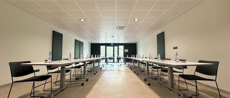 A conference room with a long table, chairs, and water bottles.