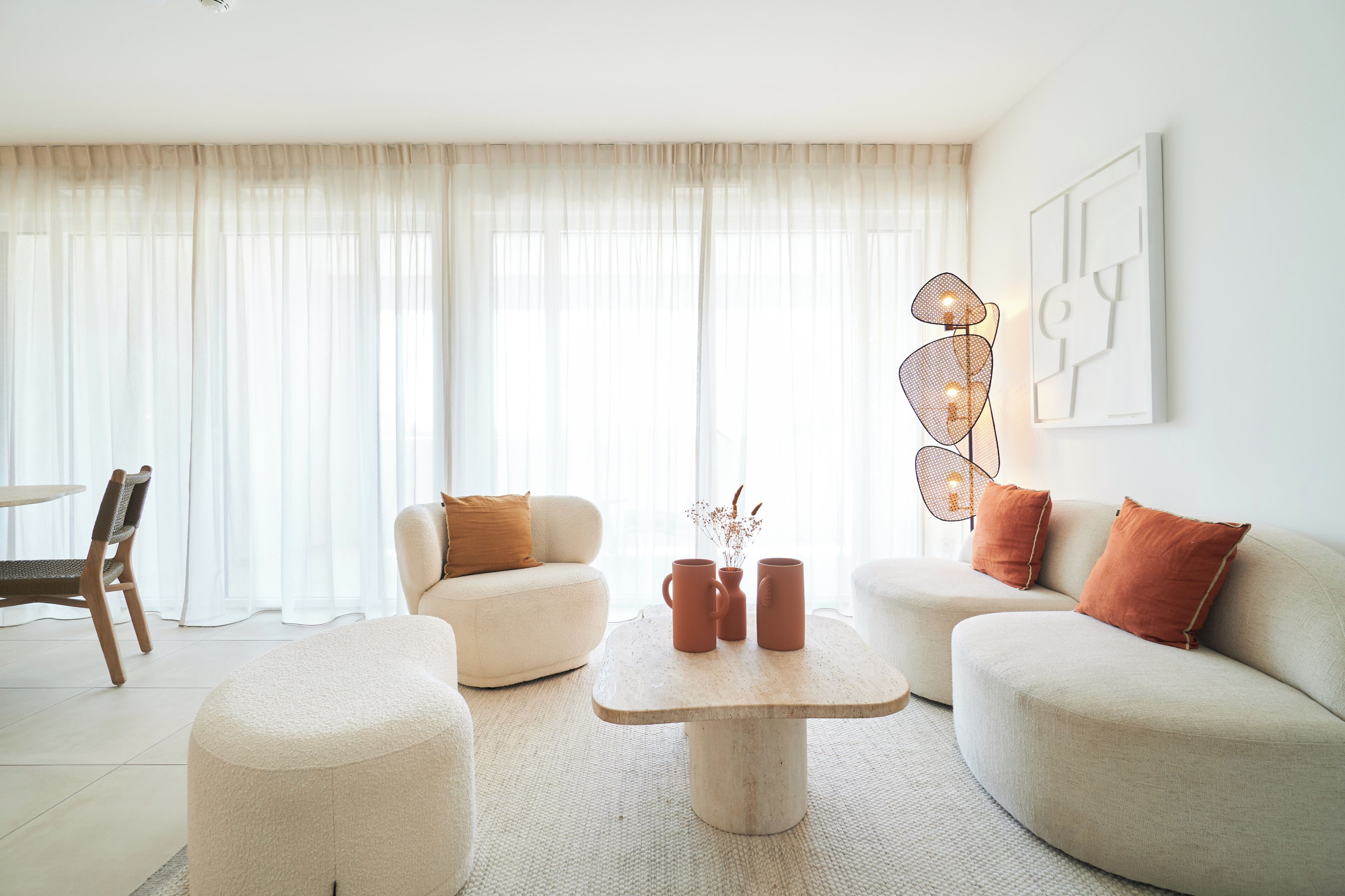 A modern living room with a sofa, ottoman, and a coffee table.