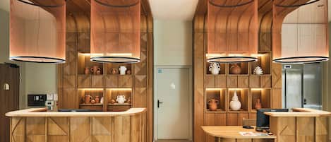 A modern kitchen with wooden cabinetry and pendant lighting.