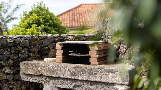 A stone wall with a brick oven and a stone bench. - Azores Element - House with pool (Ponta Delgada)
