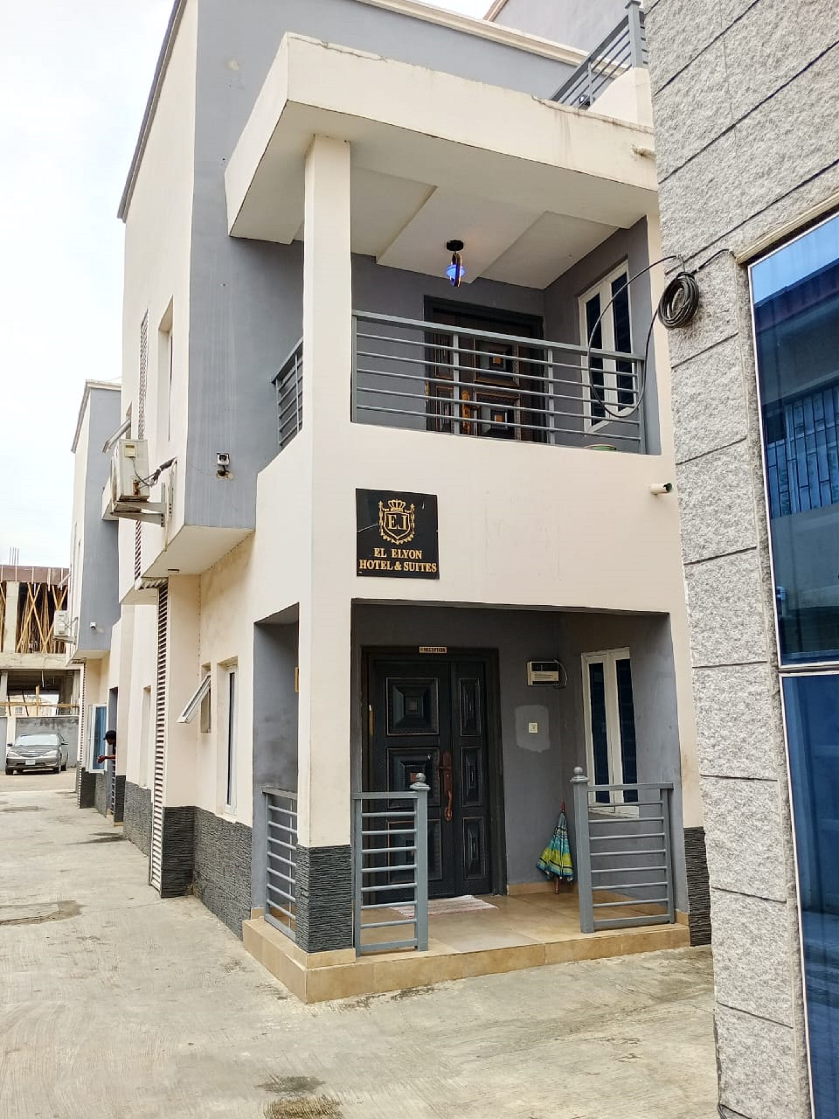 A two-story hotel with a balcony, a reception desk, and a sign indicating it is a hotel and suites.