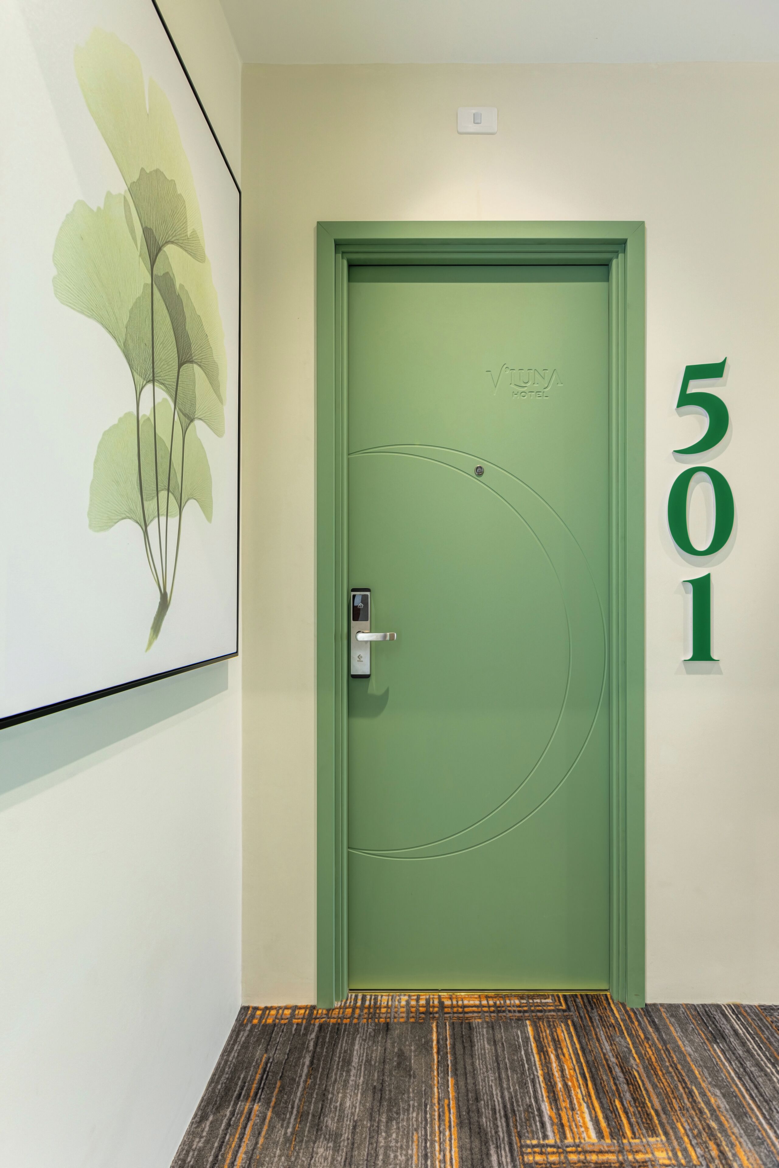 Una puerta verde con el número 501, una cerradura y un pequeño interruptor de luz arriba.
