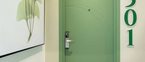 Una puerta verde con el número 501, una cerradura y un pequeño interruptor de luz arriba.