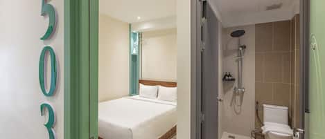 Une chambre d’hôtel avec un lit, une douche et des toilettes.