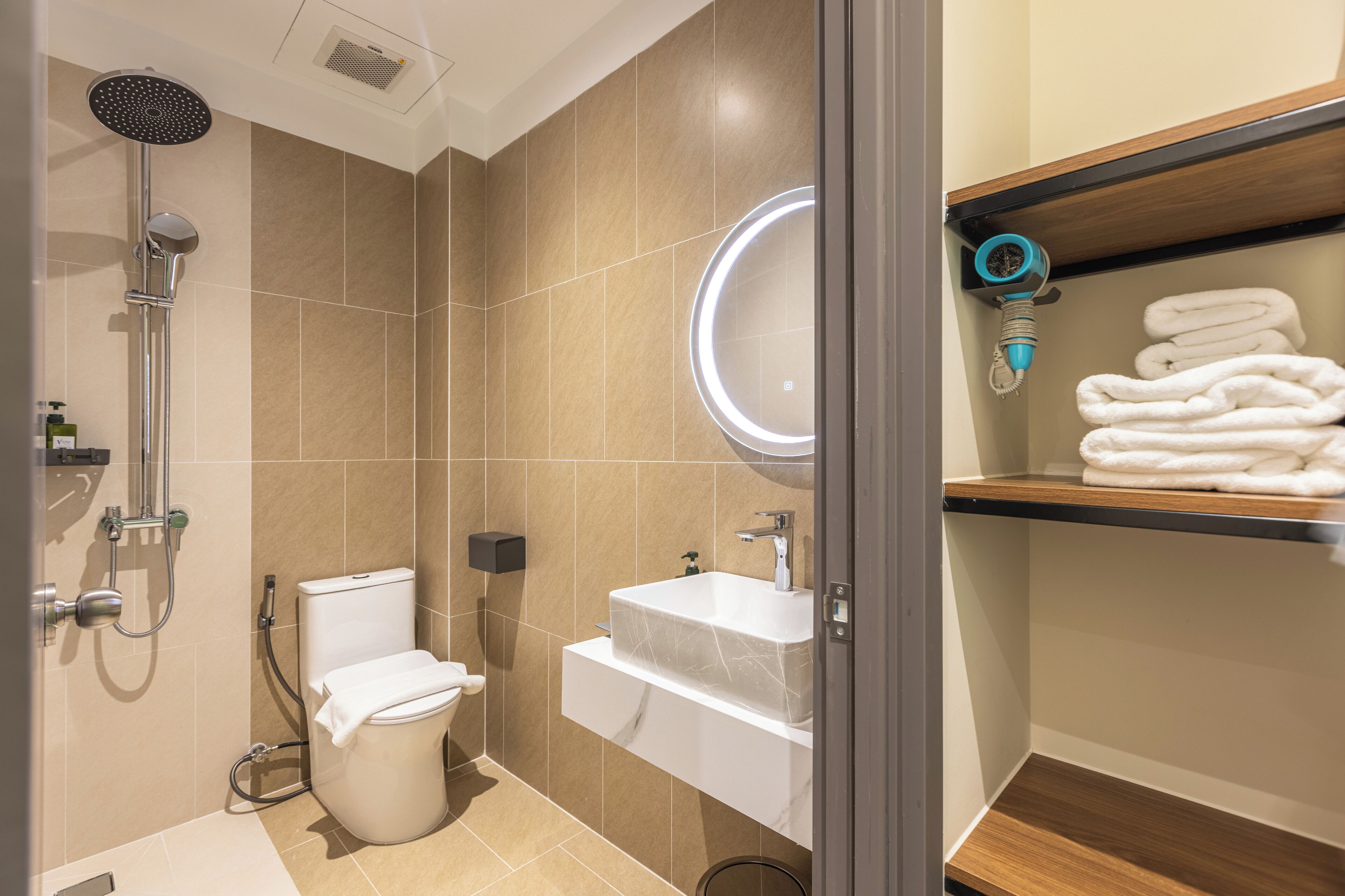 Un baño moderno con inodoro, lavamanos y ducha.